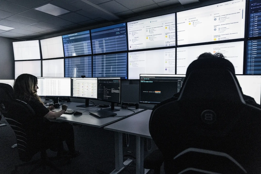 Mitarbeiter vor Monitorwand im SOC